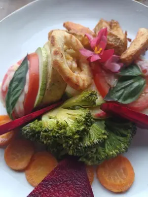 a plate of food with vegetables and a flower on it at Hotel Vistas del Cielo in Cartago