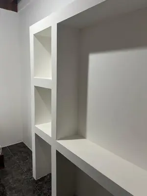 a white shelf in the corner of a room at Woodstock Hostel in Sámara