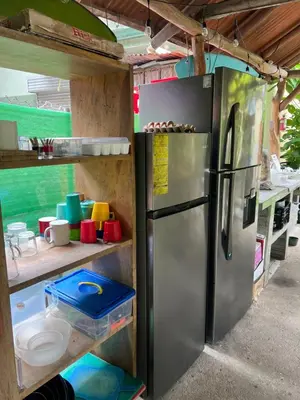 a kitchen with a stainless steel refrigerator in a trailer at Woodstock Hostel in Sámara