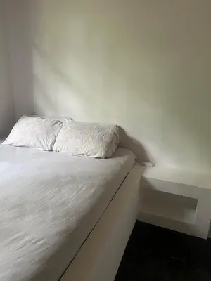 a white bed with a pillow on top of it at Woodstock Hostel in Sámara