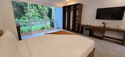 a large bedroom with a bed and a large window at Ojochal Gardens in Ojochal