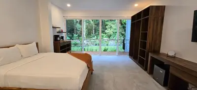 a bedroom with a white bed and a large window at Ojochal Gardens in Ojochal