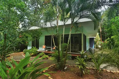a green house in the middle of a forest at Ojochal Gardens in Ojochal