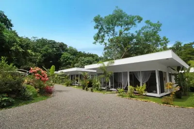 a house with a lot of plants and trees at Ojochal Gardens in Ojochal