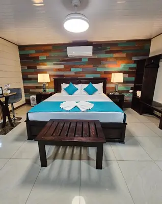 a bedroom with a bed with a bench in it at Calathea Hotel Monteverde in Monteverde Costa Rica