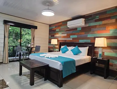 a bedroom with a bed with a wooden accent wall at Calathea Hotel Monteverde in Monteverde Costa Rica