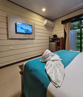 a bedroom with a bed with a tv on the wall at Calathea Hotel Monteverde in Monteverde Costa Rica