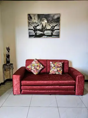 a red couch in a room with a picture on the wall at Calathea Hotel Monteverde in Monteverde Costa Rica