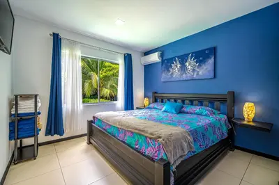 a blue bedroom with a bed and a window at Casa Sol in Carrillo