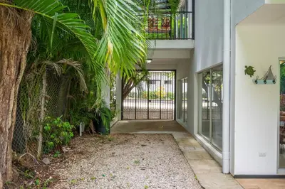an entrance to a building with a palm tree at Casa Sol in Carrillo