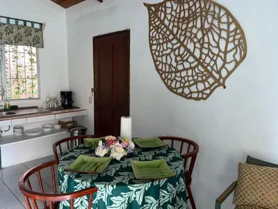a dining room table with a candle and flowers on it at Casa Hojas in Fortuna