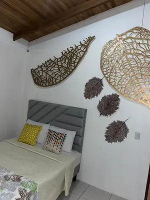 a bedroom with a bed and some decorations on the wall at Casa Hojas in Fortuna