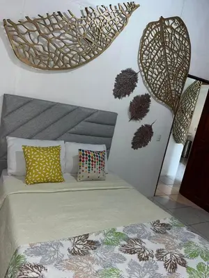 a bedroom with a bed and some decorations on the wall at Casa Hojas in Fortuna