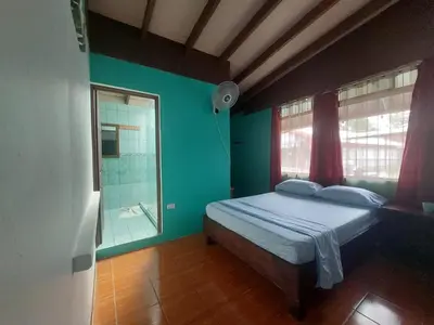 a bedroom with a bed and a glass shower at Nice Place Hostel in Fortuna