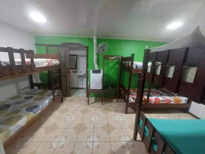 a room with three bunk beds and a bathroom at Nice Place Hostel in Fortuna