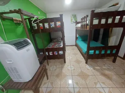 a room with two bunk beds and a fan at Nice Place Hostel in Fortuna