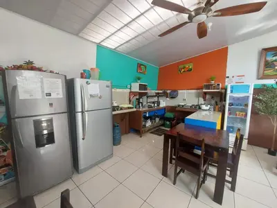 a kitchen with two refrigerators and a table in it at Nice Place Hostel in Fortuna