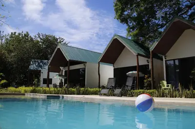 a pool with a ball in front of a house at Villas Cabuya Beach & Jungle in Cabuya