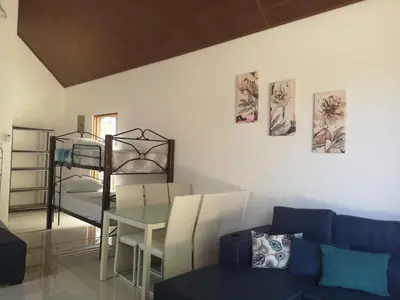a living room with a couch and a table and a bunk bed at Villas Cabuya Beach & Jungle in Cabuya