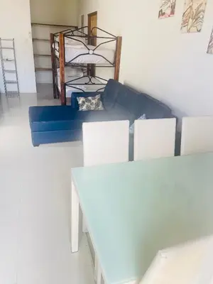 a living room with a blue couch and white chairs at Villas Cabuya Beach & Jungle in Cabuya