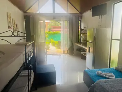 a small room with two beds and a refrigerator at Villas Cabuya Beach & Jungle in Cabuya