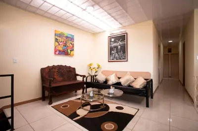 a living room with a couch and a chair at Flor de Katty Hostel Airport in Alajuela City