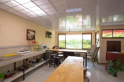 a kitchen with tables and chairs in a room at Flor de Katty Hostel Airport in Alajuela City