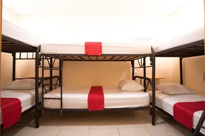 two bunk beds in a room with white and red accents at Flor de Katty Hostel Airport in Alajuela City