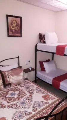 a room with two bunk beds and a rug at Flor de Katty Hostel Airport in Alajuela City