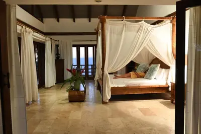 a bedroom with a bed with a canopy at Villa Nimbu in Mal País