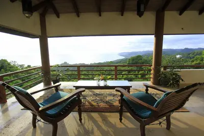 a patio with two chairs and a table on a balcony at Villa Numu in Mal País