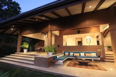 a patio with a blue couch and a table at Villa Numu in Mal País