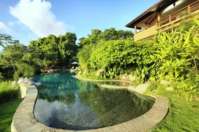 a swimming pool in the middle of a garden at Villa Numu in Mal País