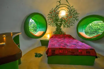 a room with a bed with four circular windows at Green Moon Lodge in Montezuma
