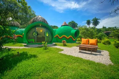 a green house with a couch in front of it at Green Moon Lodge in Montezuma