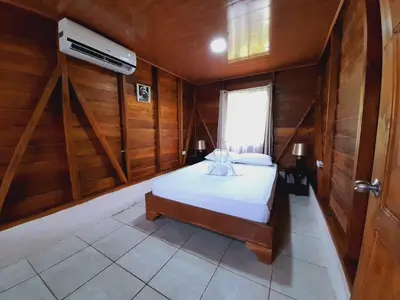 a bedroom with a bed in a wooden room at Cabaña Rural el Mirador in Fortuna