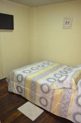 a bedroom with a bed with a blanket on it at #4 Private room close to Airport in Alajuela City