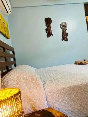 a bedroom with a bed with boots on the wall at Hotel Boruca Tamarindo in Tamarindo