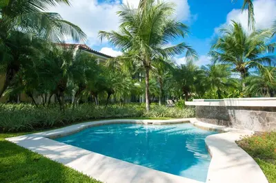 a swimming pool in a yard with palm trees at 3rd-floor space with modern décor recently renovated viewing over pool in Coco in Coco