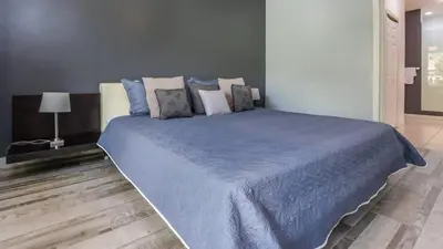 a bedroom with a large bed with blue sheets and pillows at 3rd-floor space with modern décor recently renovated viewing over pool in Coco in Coco