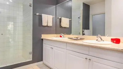 a bathroom with two sinks and a shower at 3rd-floor space with modern décor recently renovated viewing over pool in Coco in Coco