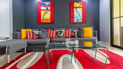 a living room with a couch and a glass table at 3rd-floor space with modern décor recently renovated viewing over pool in Coco in Coco