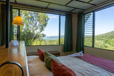 a bedroom with a bed with a cat laying on it at Arenal Observatory Lodge & Trails in Fortuna