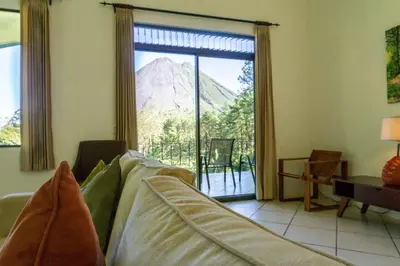 a living room with a couch and a view of a mountain at Arenal Observatory Lodge & Trails in Fortuna