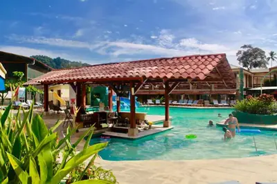a group of people in a pool at a resort at Amapola Resort in Jacó
