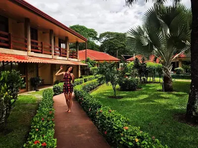 a woman walking down a sidewalk in front of a building at Amapola Resort in Jacó