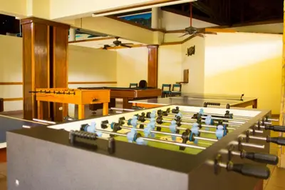a room with a foosball table and tables at Amapola Resort in Jacó