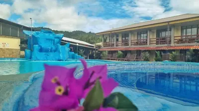 a resort with a pool and a water slide at Amapola Resort in Jacó