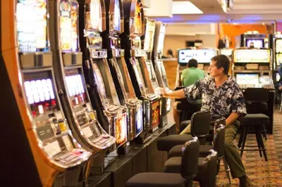a man is playing a video game in a casino at Amapola Resort in Jacó