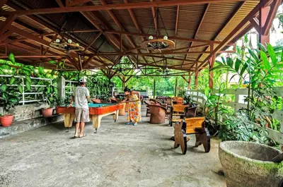 two people standing in a building with a pool table at Hotel Arenal Country Inn in Fortuna